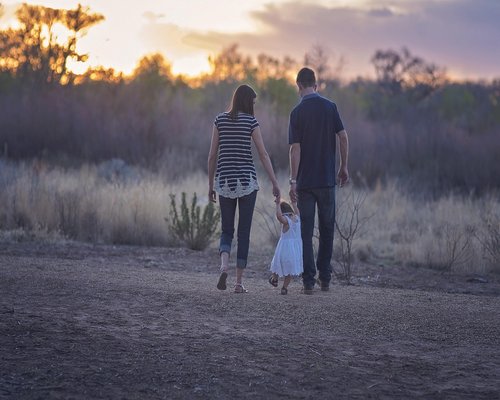Happy family walking together in the evening light